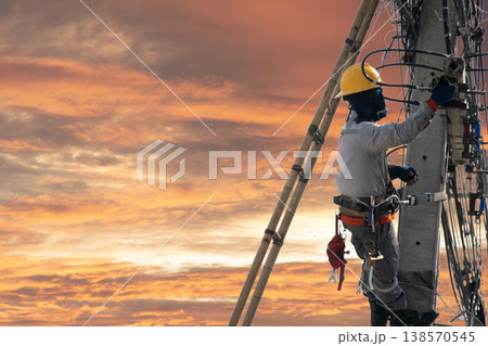Electricians work on utility poles with safety as their top priority. 138570545