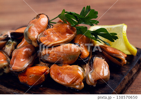 mussels without shell, boiled, mussels, peeled, on a chopping board, with lemon and parsley, mussels in Chilean, top view, no people, 138570650