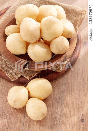 boiled new potatoes, in a wooden bowl, on a rustic table, natural light, no people, 138570674
