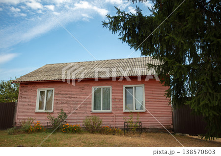 Old pink wooden house surrounded by green trees in the countryside Old pink wooden house surrounded by green trees in the countryside 138570803
