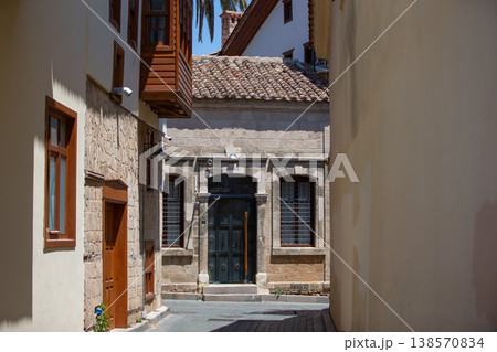 Charming narrow street in a historic village featuring stone buildings and a wooden door 138570834