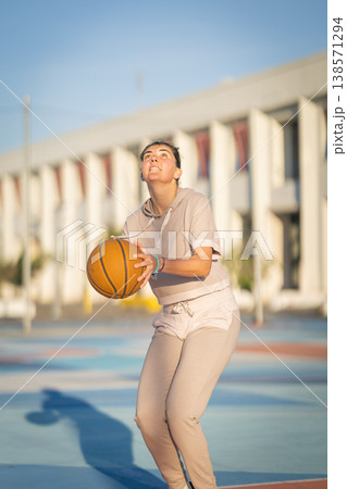 Young woman playing basketball focused on shooting 138571294