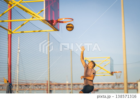Man playing basketball on outdoor court urban lifestyle Man playing basketball on outdoor court urban lifestyle 138571316