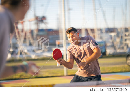 Man concentrating playing table tennis outdoors Man concentrating playing table tennis outdoors 138571340