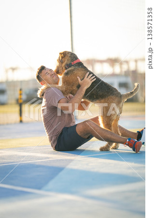 Man playing with dog receiving happy licks Man playing with dog receiving happy licks 138571358