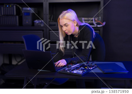 Female IT technician in her 20s repairing a laptop and motherboard in a tech lab 138571950