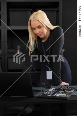 Female IT technician with laptop and hardware setup performing diagnostics and repair 138571951