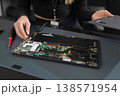 Female IT technician in her 20s repairs a laptop motherboard during a professional repair session 138571954