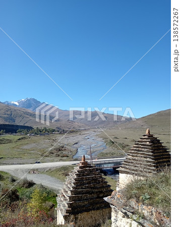 Dargavs necropolis, City of the Dead, North Ossetia, Russia. Ancient stone crypts with pointed roofs on a green mountain slope 138572267