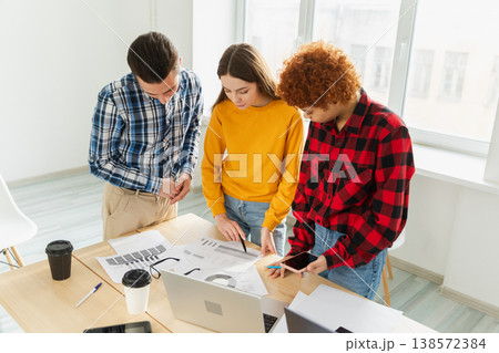 Teamwork brainstorm young professional team concept. Happy multiracial coworkers cooperating working together at office meeting. Diverse colleagues discussing project ideas editing documentation 138572384