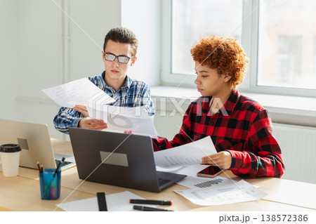 Teamwork brainstorm. Diverse colleagues working together discuss financial statistics. Group of happy young modern people sitting in creative office discussing business. Young professional team 138572386