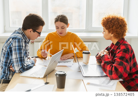 Teamwork brainstorm. Diverse colleagues working together discuss financial statistics. Group of happy young modern people sitting in creative office discussing business. Young professional team 138572405
