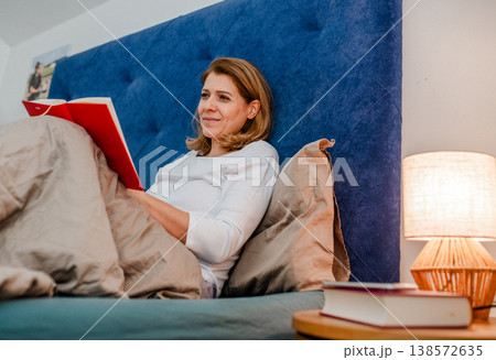 Nighttime routine for mature woman, reading book. Nighttime routine for mature woman, reading book. 138572635
