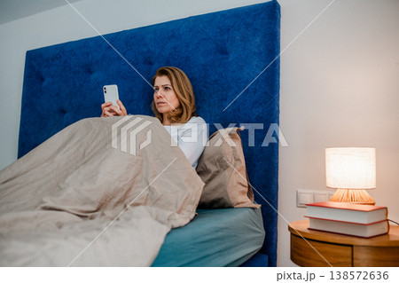 Nighttime routine for mature woman, scrolling on phone. Nighttime routine for mature woman, scrolling on phone. 138572636
