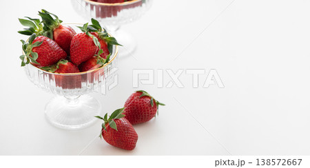 Summer Strawberries in Elegant Glass Bowls on White Table 138572667