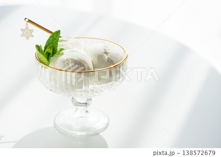 Vanilla Ice Cream in Elegant Glass Bowls on White Table with Sunlight 138572679