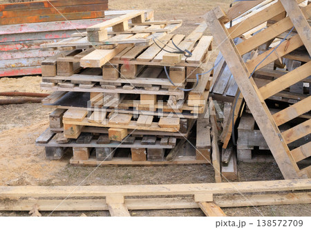 Wooden pallets at a construction site. Used stacked wooden pallets used for storing building materials Wooden pallets at a construction site. Used stacked wooden pallets used for storing building materials 138572709