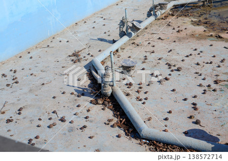 Technical equipment at the bottom of a drained city fountain, requiring post-winter cleaning. 138572714