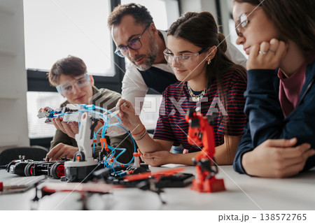 High school students working on robotics project with their teacher. High school students working on robotics project with their teacher. 138572765