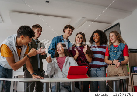 Teen students learning together with digital tablet in modern classroom. 138572769