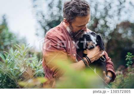 Man hugging senior dog with affection. Man hugging senior dog with affection. 138572805