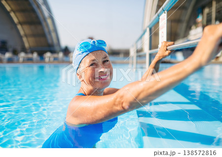 Elderly woman in swimming pool. Older female exercising for vitality and longevity. 138572816