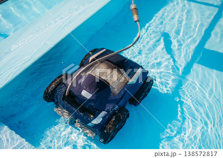 Robotic pool cleaner working underwater to keep swimming pool clean. 138572817