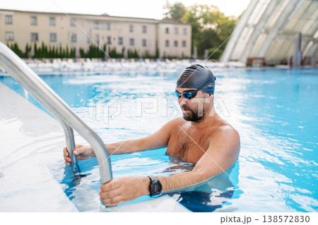 Male swimmer getting out of the pool after swim training. Male swimmer getting out of the pool after swim training. 138572830