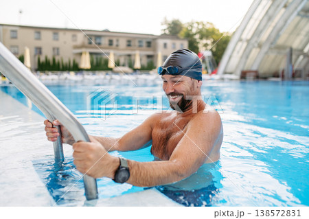 Male swimmer getting out of the pool after swim training. 138572831