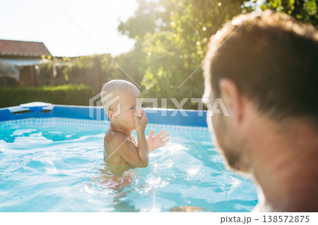 Father playing with little son in pool. Father playing with little son in pool. 138572875