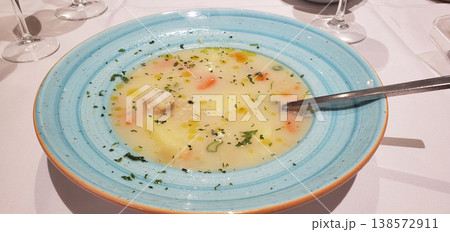 chicken broth or soup with vegetables and quail meat in a round plate, top view 138572911
