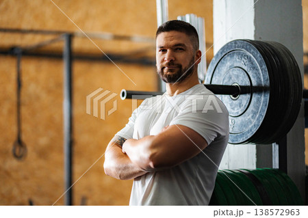 Muscular man standing in gym with arms crossed Muscular man standing in gym with arms crossed 138572963