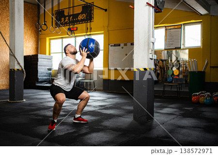 Man doing medicine ball wall ball exercise workout 138572971