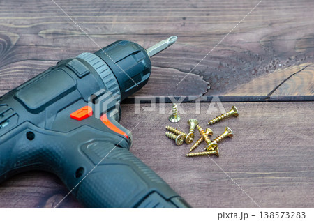 Set of fasteners and power tool demonstrate preparation for installation 138573283