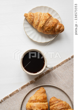 Freshly bakery croissants and cup of coffee on a white table with napkin. Freshly bakery croissants and cup of coffee on a white table with napkin. 138573353