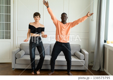 Couple of young man and woman dancing at home Couple of young man and woman dancing at home 138573795