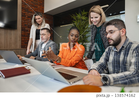 Group of People Sitting Around a Table With Laptops Group of People Sitting Around a Table With Laptops 138574162