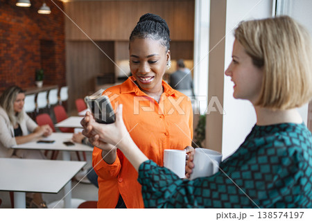 Woman Holding Cell Phone and Coffee Woman Holding Cell Phone and Coffee 138574197
