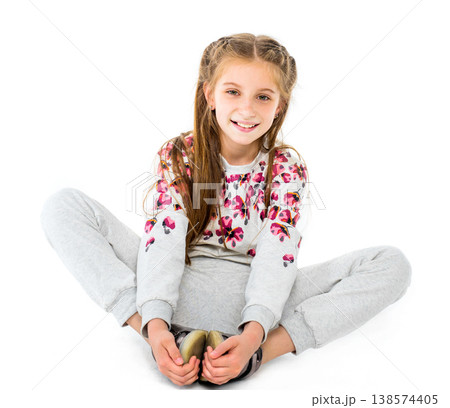 Beautiful teenage girl do seated butterfly stretch and smiles isolated on white background 138574405