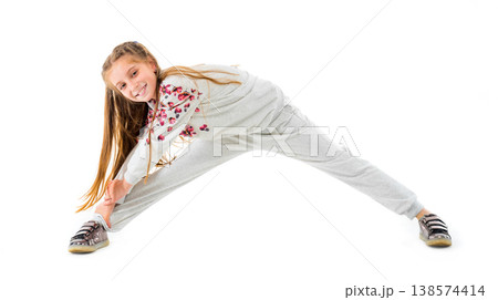 Little girl do stretching exercise in grey fashion sportwear isolated on white background Little girl do stretching exercise in grey fashion sportwear isolated on white background 138574414