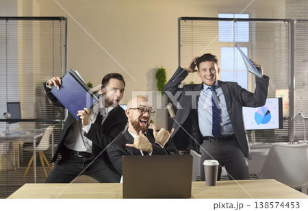 Excited businessmen cheering by laptop in office, playful teamwork success 138574453