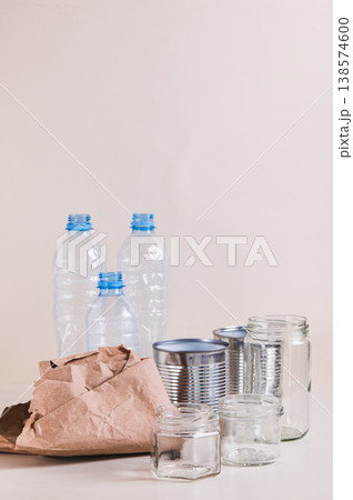 Paper, glass, metal and plastic for separate waste collection on the table vertical view Paper, glass, metal and plastic for separate waste collection on the table vertical view 138574600