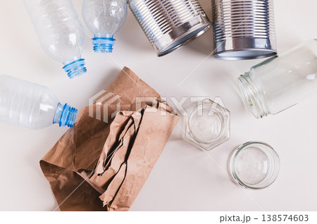 Paper, glass, metal and plastic for separate waste collection on the table top view 138574603