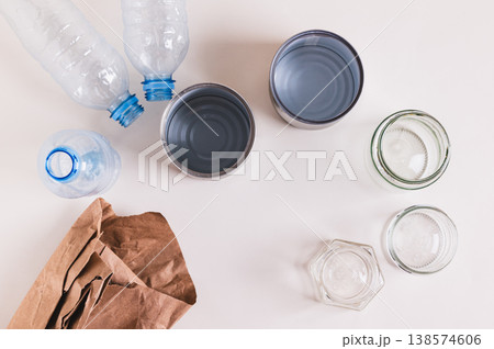 Close up of paper, glass, metal and plastic for separate waste collection on the table top view Close up of paper, glass, metal and plastic for separate waste collection on the table top view 138574606