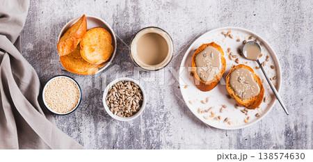 Toast with sesame and sunflower tahini on a plate on the table top view web banner 138574630