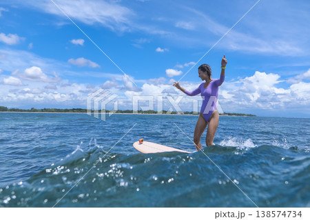 Teenage Girl Skillfully Balancing On Wave During Serene Coastal Surfing Session Teenage Girl Skillfully Balancing On Wave During Serene Coastal Surfing Session 138574734