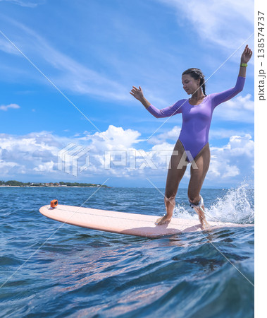 Lively Woman Skillfully Maintains Stance On Surfboard Amid Stormy Sky Lively Woman Skillfully Maintains Stance On Surfboard Amid Stormy Sky 138574737