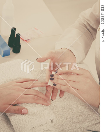 Woman making manicure using nail polish remover 138574832