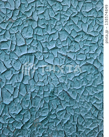 The detailed texture of old turquoise blue paint. The paint has cracks and is peeling from a flat surface, capturing the effects of time and weather. The detailed texture of old turquoise blue paint. The paint has cracks and is peeling from a flat surface, capturing the effects of time and weather. 138574849