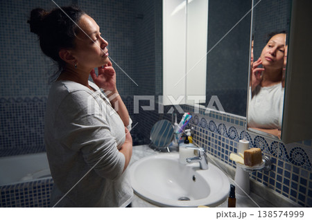 Middle Aged Woman in Pyjamas Caring for Her Face During Morning Beauty Routine Middle Aged Woman in Pyjamas Caring for Her Face During Morning Beauty Routine 138574999